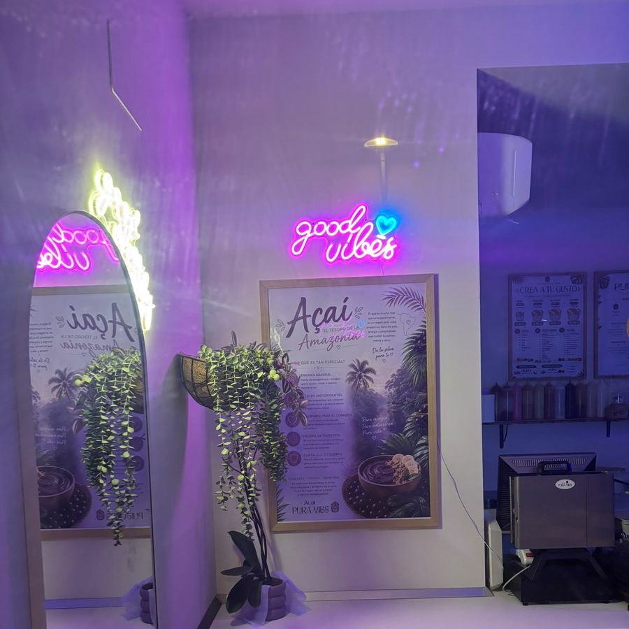 Neón manuscrito 'good vibes' en el interior de Açaí Pura Vibe